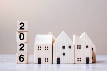 2026 Happy New Year with house model on table wooden background. Banking, real estate, investment,...