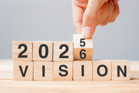 hand flipping block 2025 to 2026 VISION text on table. Resolution, strategy, goal, motivation, reboot, business and New Year holiday conceptsの写真素材