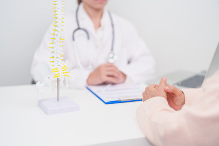 Elderly Patient consulting Doctor with Spine anatomy for Spinal Cord Disorder and disease, Back pain, Lumbar, Sacral pelvis, Cervical neck, Thoracic, Coccyx, Orthopedist, chiropractic, Office Syndromeの写真素材