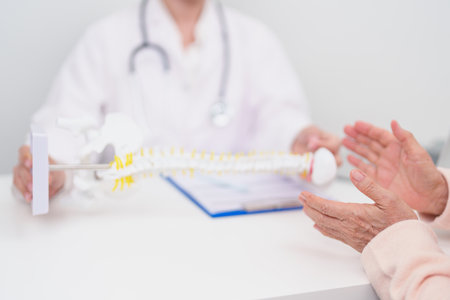 Elderly Patient consulting Doctor with Spine anatomy for Spinal Cord Disorder and disease, Back...