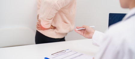 Elderly woman having back body ache and consulting doctor in hospital. Senior female with muscle pain due to Piriformis Syndrome, Low Back Pain and Spinal Compression. Office syndrome and medicalの写真素材