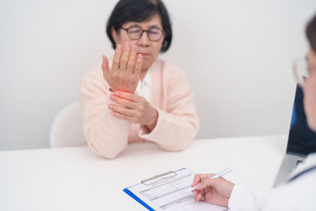 Elderly Patient Woman wrist pain and Consulting doctor. muscle ache from Carpal Tunnel Syndrome, De Quervain s tenosynovitis, rheumatoid, arthritis, gout, Parkinson disease and ergonomic healthcareの写真素材