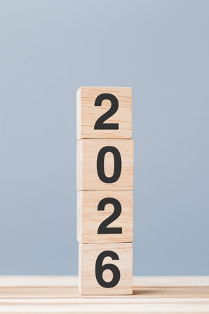 wooden cube block with 2026 text on table background. Resolution, plan, review, goal, start and New...