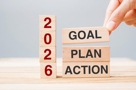 hand holding wooden block with text 2026 GOAL, PLAN and ACTION on table background. Resolution,...
