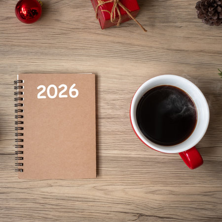 2026 notebook, black coffee cup and Christmas gift on wood table, Top view and copy space. Xmas, Happy New Year, Goals, Resolution, To do list, Strategy and Plan conceptの写真素材