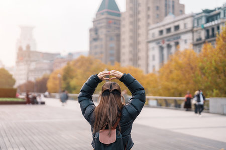 woman traveler visiting in Shanghai, China. Happy Female Tourist sightseeing Shanghai view in The Bund of Shanghai in Autumn season. landmark and popular for tourism attractions. Travel and Vacationの写真素材