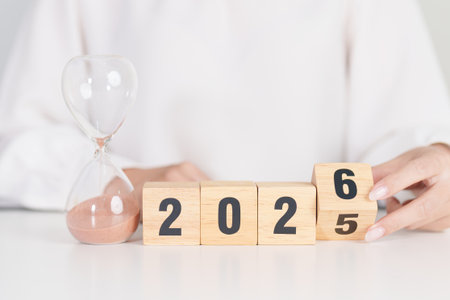 2025 end year to Happy New Year 2026 with hourglass on table. Resolution, time, plan, goal,...