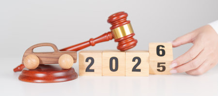 2025 end year to Happy New Year 2026 with small toy car models and Judges gavel on desk in...