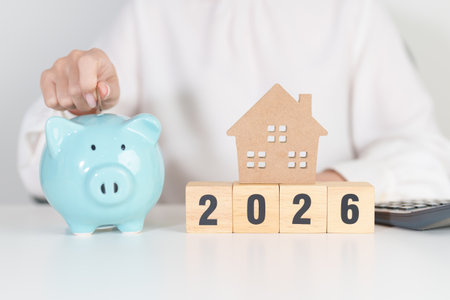 Happy New Year 2026 with house model and Coins stack. real estate, Home loan, tax, investment,...