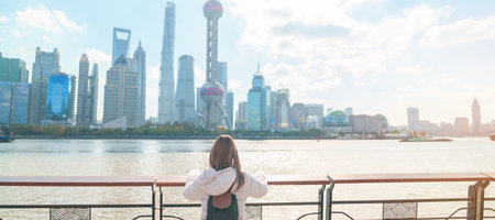 woman traveler visiting in Shanghai, China. Female Tourist with backpack sightseeing Shanghai view...