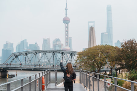 woman traveler visiting in Shanghai, China. Happy Female Tourist sightseeing Oriental Pearl Tower and Waibaidu Bridge view. landmark and popular for tourism attractions. Travel and vacation conceptの写真素材