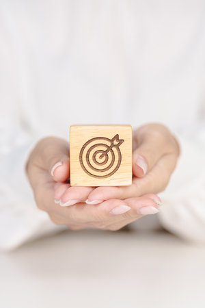 hand hold dartboard block with business goal, strategy, target, mission, action, objective, aim and...