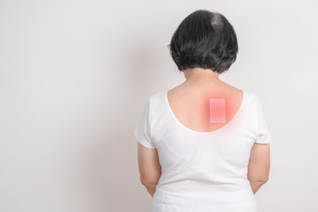Business woman having back ache with Medicated pain relief patch plaster for Back Muscle Strain,...