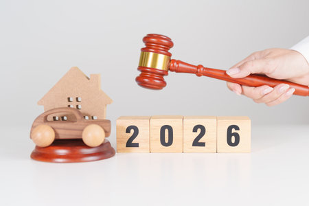 Happy New Year 2026 with house and Car model and gavel justice hammer on desk in courthouse. Real...