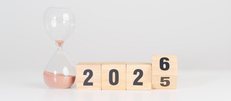 2025 end year to Happy New Year 2026 with hourglass on table. Resolution, time, plan, goal,...