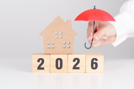 Happy New Year 2026 with red umbrella over money stack. Insurance, real estate, Home loan, tax,...