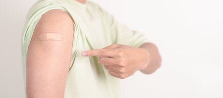 Adult Man with bandage after received vaccine. Vaccination and Immunization for Influenza, HPV, Zoster, IPD, DTP or Diphtheria, Tetanus and Pertussis, MMR, Hepatitis B, Covid and Varicella vaccineの写真素材