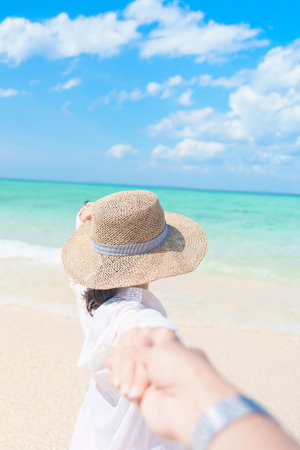 couple tourist relaxing and enjoying on beach, happy traveller looking beautiful sea view on tropical island. Honeymoon, tropical destination, southeast Asia Travel, summer vacation and wanderlustの写真素材