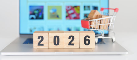 Happy new year with 2026 block in shopping trolley cart on table. E commerce, online shopping, finance, consumer economy and celebration conceptsの写真素材