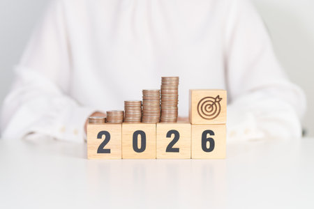 Happy New Year 2026 with Coins stack and dartboard icon. Strategy, goal, Money, Budget, tax, investment, financial, savings and New Year Resolution conceptsの写真素材
