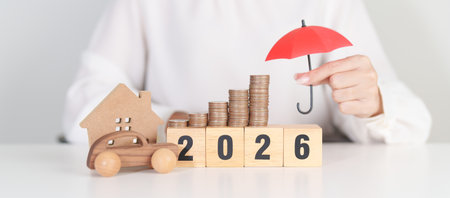 Happy New Year 2026 with red umbrella over money stack. Insurance, real estate, Home, car, loan,...