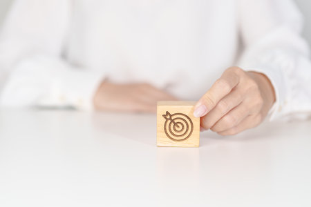 hand hold dartboard block with business goal, strategy, target, mission, action, objective, aim and...