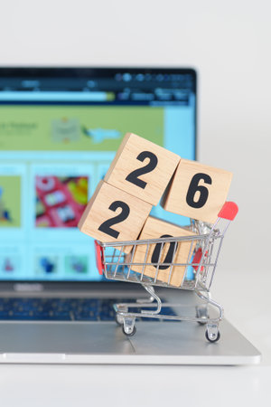 Happy new year with 2026 block in shopping trolley cart on table. E commerce, online shopping, finance, consumer economy and celebration conceptsの写真素材
