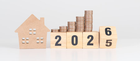2025 end year to Happy New Year 2026 with house model and Coins stack. real estate, Home loan, tax, investment, mortgage, financial, savings and New Year Resolution conceptsの写真素材