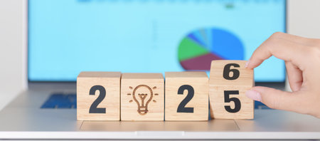 2025 end year to Happy New Year 2026 block with lightbulb icon against computer laptop background....