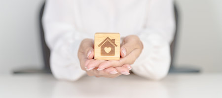 Hand Holding Home with Heart block. Property investment, House Mortgage, Real Estate tax, homeless, donation, Financial and happy family conceptsの写真素材