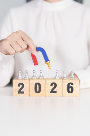 hand holding magnet and pulling man chess figure from the crowd employee with 2026 Year block. Human resource management, Recruitment, Teamwork, strategy, leadership Conceptsの写真素材
