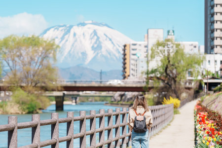 Woman tourist sightseeing Iwate mountain and Kitakami river with flowers in Spring, happy traveler travel in Morioka city, Iwate prefecture, Japan. famous Landmark Travel and Vacation destinationの写真素材