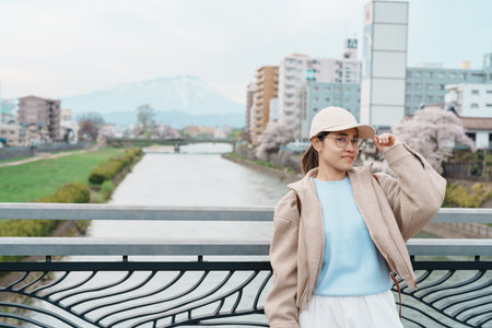 Woman tourist sightseeing Iwate mountain and Kitakami river with flowers in Spring, happy traveler travel in Morioka city, Iwate prefecture, Japan. famous Landmark Travel and Vacation destinationの写真素材