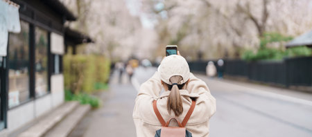 Woman tourist sightseeing and taking photo Sakura Cherry Blossom in Spring. traveler travel in Samurai village in Kakunodate town, Semboku District, Akita Prefecture, Japan. Landmark and vacationの写真素材