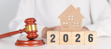 Happy New Year 2026 with small toy house model with gavel justice hammer on desk in courthouse. Real...