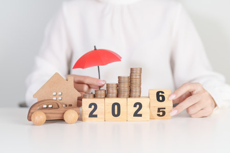 2025 end year to Happy New Year 2026 with red umbrella over money stack. Insurance, real estate, Home, car, loan, tax, investment, mortgage, financial, savings, protection and safetyの写真素材