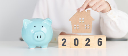 Happy New Year 2026 with house model and Coins stack. real estate, Home loan, tax, investment,...