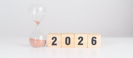 Happy New Year 2026 with hourglass on table. Resolution, time, plan, goal, motivation, reboot, countdown and New Year holiday conceptsの写真素材
