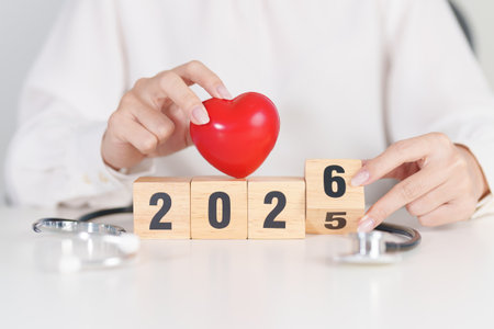 2025 end year to Happy New Year 2026 with Stethoscope of doctor and heart shape on table. health care, Insurance, Wellness and medical conceptsの写真素材