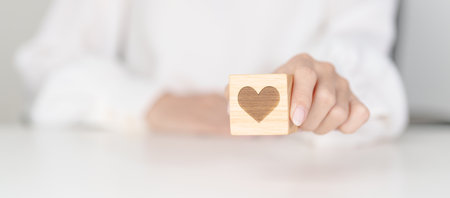 Hand holding heart block for health care, love, organ donation, charity, happy family, wellbeing and insurance concepts. world heart day, health day and mental health dayの写真素材