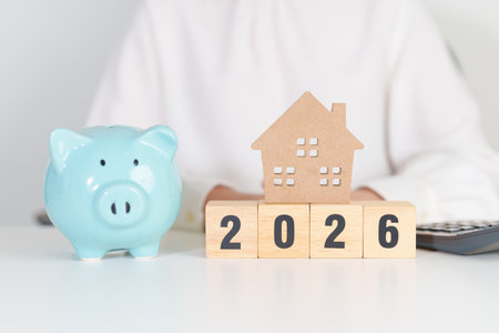 Happy New Year 2026 with house model and Coins stack. real estate, Home loan, tax, investment,...