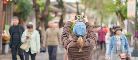 Happy woman traveler travel in Chengdu city. Tourist sightseeing and taking photo in Kuan Zhai Alley or wide and narrow  alleys, Famous Landmark for tourism attraction in Sichuan, Chinaの写真素材