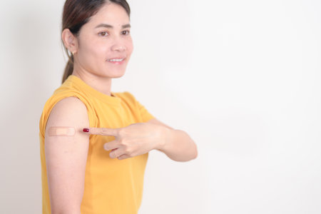 Adult Woman with bandage after received vaccine. Vaccination and Immunization for Influenza, HPV, Zoster, IPD, DTP or Diphtheria, Tetanus and Pertussis, MMR, Hepatitis B, Covid and Varicella vaccineの写真素材