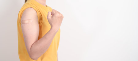 Adult Woman with bandage after received vaccine. Vaccination and Immunization for Influenza, HPV, Zoster, IPD, DTP or Diphtheria, Tetanus and Pertussis, MMR, Hepatitis B, Covid and Varicella vaccineの写真素材