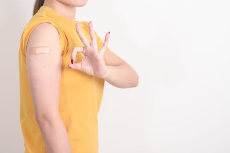 Adult Woman with bandage after received vaccine. Vaccination and Immunization for Influenza, HPV, Zoster, IPD, DTP or Diphtheria, Tetanus and Pertussis, MMR, Hepatitis B, Covid and Varicella vaccineの写真素材