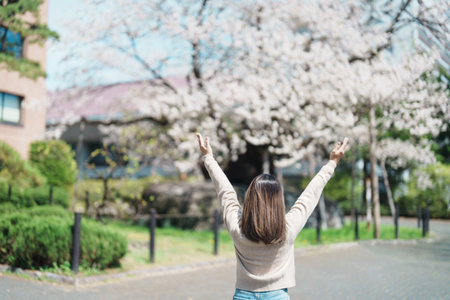 Woman tourist sightseeing Rock breaking Cherry Tree or Ishiwarizakura in Spring, happy traveler...