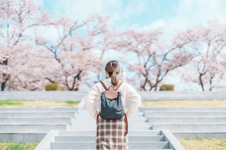 Woman tourist sightseeing Tendo Park or Maizuru Park with Sakura Cherry Blossom in Spring, happy...