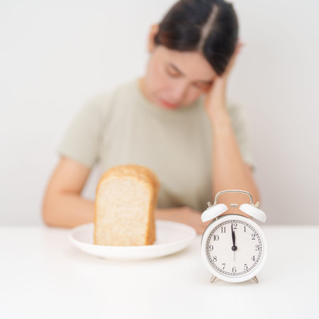 hungry woman with whole wheat bread and clock. concept of intermittent fasting, IF, meal, Time to...