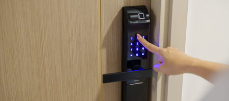 Hand press PIN number for smart digital door lock while open or close the door at home or apartment....