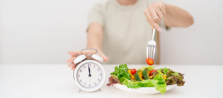 happy smiling woman with fresh organic vegetables plate and alarm clock. intermittent fasting, IF,...